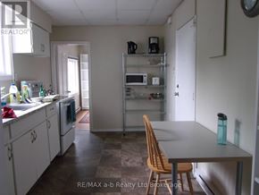 Woodstock (Woodstock - South) apartment for rent - A kitchen with a table and chairs in the foreground and a microwave on the shelves.