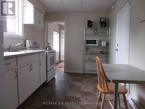 Woodstock (Woodstock - South) apartment for rent - A kitchen with white cabinets and a wooden chair.