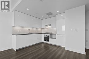 Vancouver apartment for rent - A modern kitchen with white cabinets and a wooden floor.