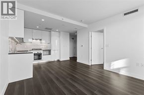 Vancouver apartment for rent - A modern kitchen with dark wood floors and white cabinetry.