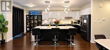Ottawa townhouse for rent - A modern kitchen with black bar stools and a wooden floor.