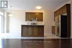 Oakville (Go Glenorchy) townhouse for rent - A kitchen with wooden cabinets and a refrigerator.