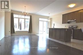 Oakville (Go Glenorchy) townhouse for rent - A spacious kitchen and living room with dark wood floors and white walls.