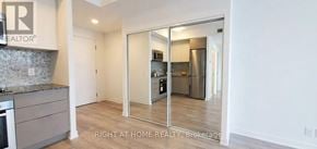 Toronto (Moss Park) condo for rent - A kitchen with a refrigerator, sink, and cabinets.