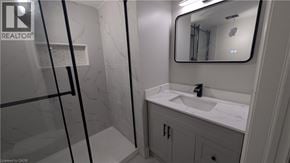 Hamilton apartment for rent - A bathroom with a sink, mirror, and shower.