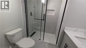 Hamilton apartment for rent - A white toilet in a bathroom with a glass shower door.