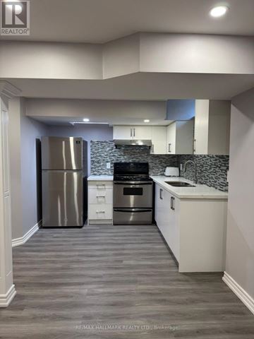 Richmond Hill (Oak Ridges Lake Wilcox) apartment for rent - A modern kitchen with a stainless steel refrigerator and a tiled backsplash.