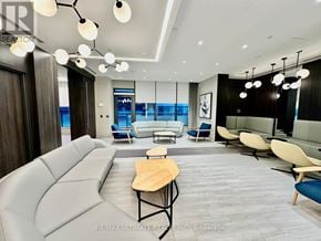 Toronto (Islington-City Centre West) condo for rent - A modern living room with a grey sofa and a wooden table.