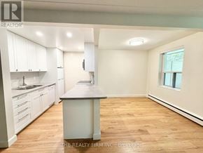 London South (South F) condo for rent - A kitchen with white cabinets and a wooden island.