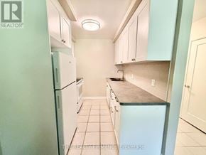 London South (South F) condo for rent - A kitchen with white cabinets and a refrigerator.