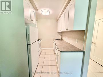 London South (South F) condo for rent - A kitchen with white cabinets and a refrigerator.
