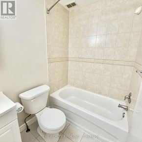 London South (South F) condo for rent - A white toilet sits next to a bathtub in a bathroom.