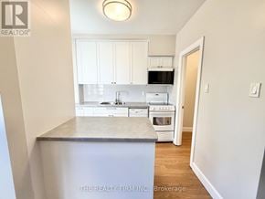 London South (South F) condo for rent - A kitchen with white cabinets and appliances is shown.