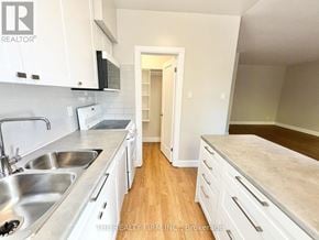 London South (South F) condo for rent - A kitchen with white cabinets and a sink.