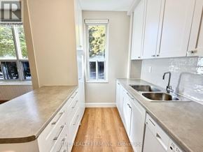London South (South F) condo for rent - A kitchen with white cabinets and a window.