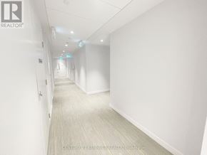Toronto (Kensington-Chinatown) condo for rent - A long hallway with white walls and a light grey carpet.