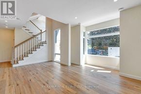 Ottawa apartment for rent - A spacious room with wooden flooring and a staircase.