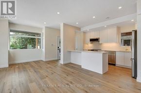 Ottawa apartment for rent - A spacious kitchen and living room with wooden floors and white walls.