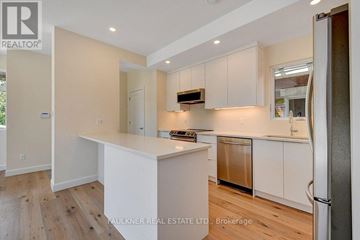 Ottawa apartment for rent - A kitchen with white cabinets and a wooden floor.