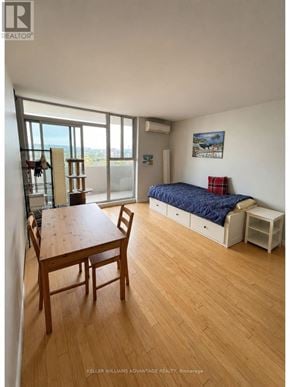 Toronto (Cabbagetown-South St. James Town) condo for rent - A bedroom with a bed, a table and chairs, and a window overlooking the ocean.