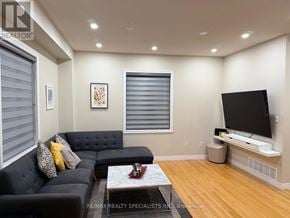 Brampton (Northwest Sandalwood Parkway) apartment for rent - A living room with a black couch and a flat screen TV.