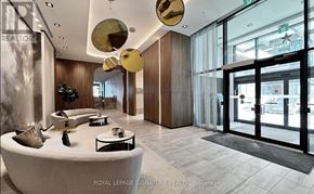 Pickering (Bay Ridges) condo for rent - A modern interior space with a curved white couch and a glass door.