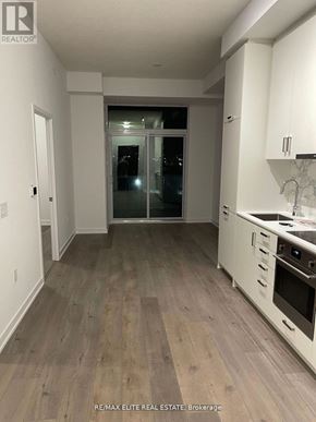 Vaughan (Vaughan Corporate Centre) condo for rent - A kitchen with white cabinets and a wooden floor.