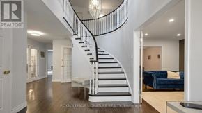 Oakville (Ga Glen Abbey) apartment for rent - A white interior with a spiral staircase and a blue couch.