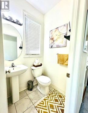 Brant (Paris) townhouse for rent - A bathroom with a toilet, sink, and mirror.