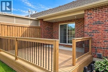 Lakeshore townhouse for rent - A wooden deck with a railing and a brick house in the background.