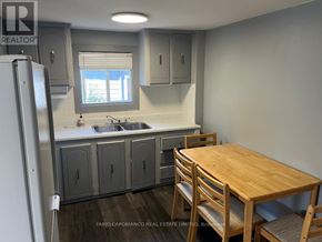 Mississauga (Lakeview) apartment for rent - A kitchen with a wooden table and chairs.