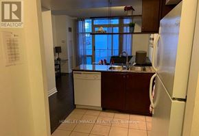 Toronto (Waterfront Communities) condo for rent - A kitchen with a refrigerator, sink, and cabinets.