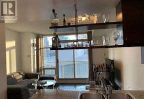 Toronto (Waterfront Communities) condo for rent - A well-lit kitchen and living room with a large window and a bar area.