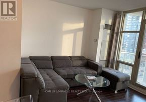 Toronto (Waterfront Communities) condo for rent - A living room with a grey sofa and a glass table.
