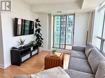Toronto (Willowdale East) condo for rent - A living room with a grey couch and a wooden coffee table.
