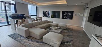 Mississauga (Port Credit) condo for rent - A living room with a large sectional sofa and a coffee table.