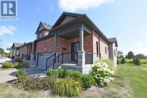 Simcoe townhouse for rent - A house with a brick exterior and a black metal railing on the steps.