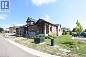 Simcoe townhouse for rent - A house with a car parked in front of it.
