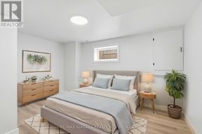 Hamilton (Mcquesten) apartment for rent - A bedroom with a bed, nightstands, and a plant.