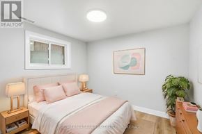 Hamilton (Mcquesten) apartment for rent - A bedroom with a bed, nightstand, and a plant.