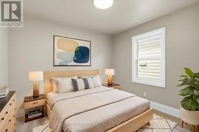 Hamilton (Mcquesten) apartment for rent - A bedroom with a large bed, two lamps, and a painting on the wall.