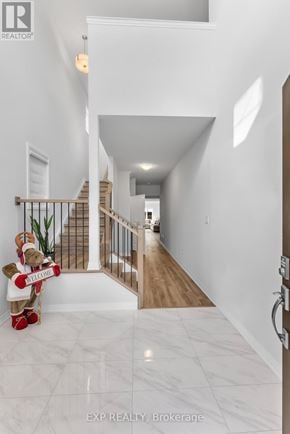 Pelham (Fonthill) apartment for rent - A hallway with a white marble floor and a wooden staircase.