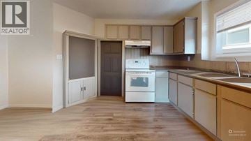 Lethbridge apartment for rent - A kitchen with a white stove top oven and wooden flooring.