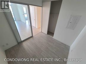 Vaughan (Vaughan Corporate Centre) condo for rent - A room with a wooden floor and white walls, with a glass door leading to another room.