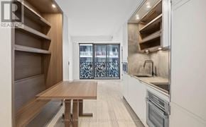 Toronto (Church-Yonge Corridor) condo for rent - A modern kitchen with a wooden table and stainless steel appliances.