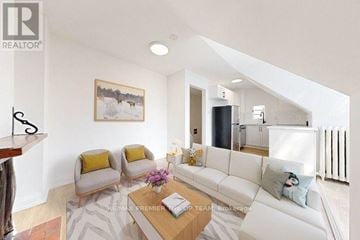 Toronto (The Beaches) apartment for rent - A living room with a white couch, a coffee table, and a painting on the wall.