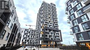 Oakville (Jm Joshua Meadows) condo for rent - A tall residential building stands in front of two smaller buildings.