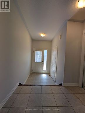 Cambridge townhouse for rent - A hallway with a door on the right and a window on the left.