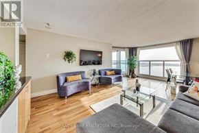 Toronto (Waterfront Communities) condo for rent - A living room with a grey couch, a purple armchair, and a glass coffee table.