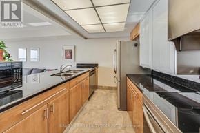 Toronto (Waterfront Communities) condo for rent - A kitchen with wooden cabinets and a stainless steel refrigerator.